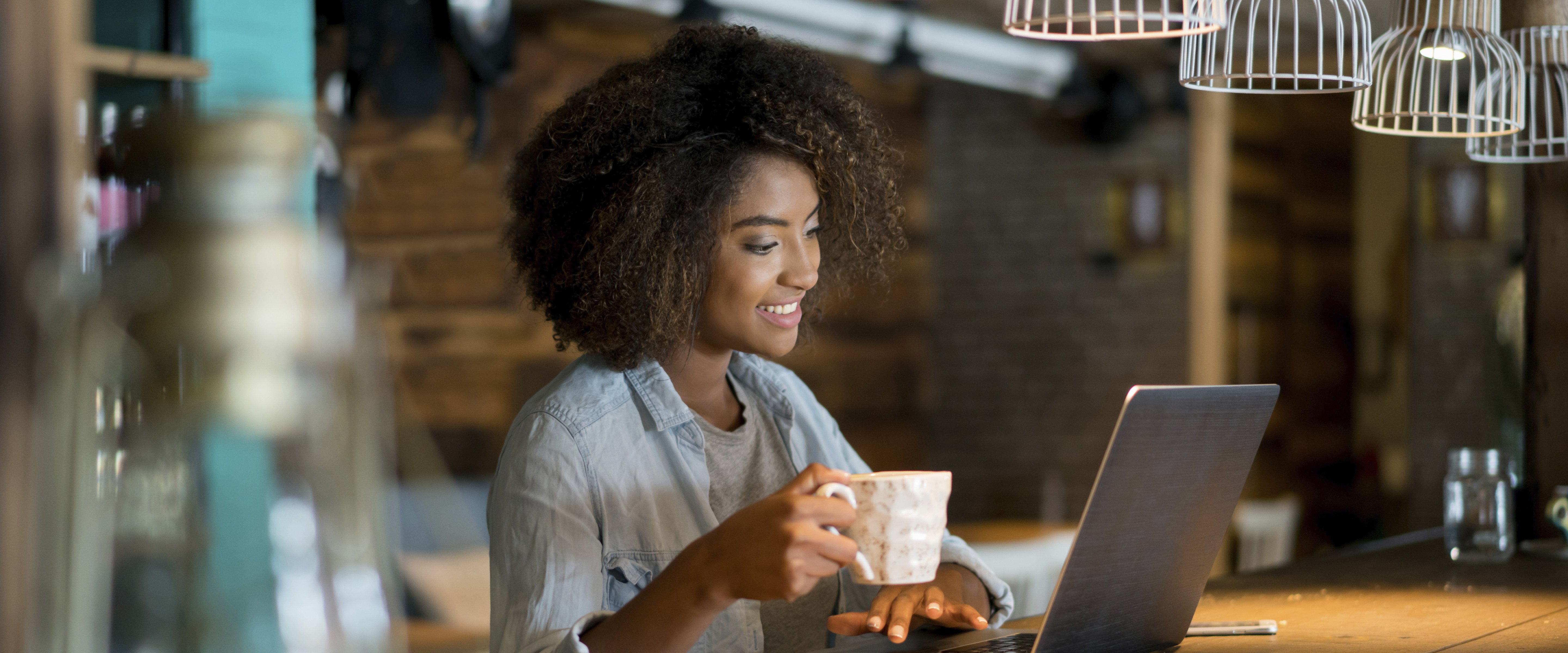 woman in rustic coffee shop working on laptop