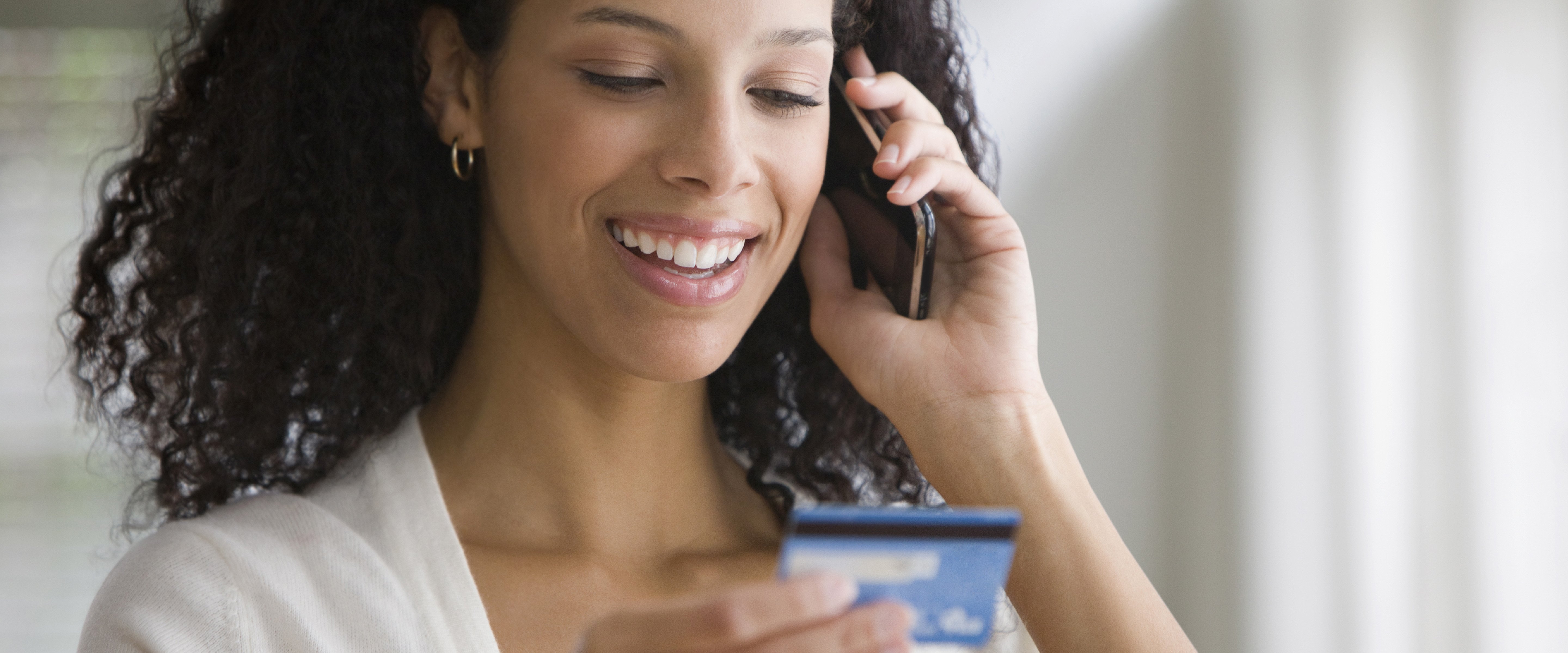 young woman on mobile phone using credit card
